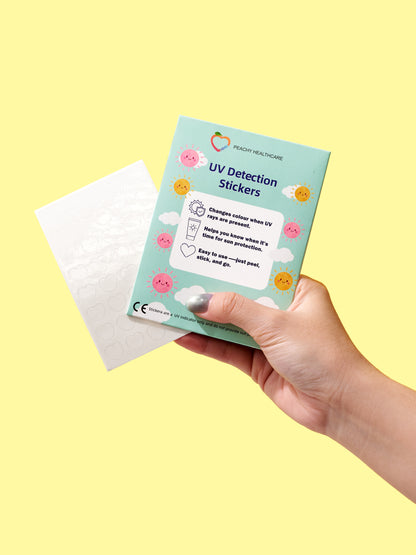 Hand holding a UV Detection Stickers card and sticker sheet on a bright yellow background